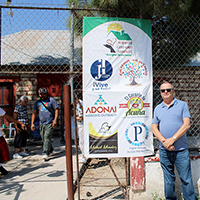 Bob Decker at entrance to shelter next to sign